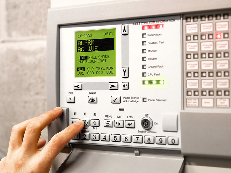 A technician tests a fire alarm panel.