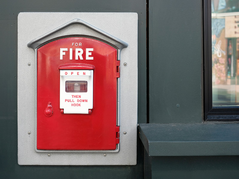 Red Gamewell Fire Box on gray building in Boston, Massachusetts 